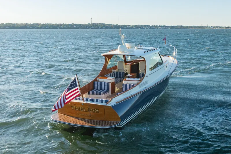 Slide: The Image of 2015 Hinckley Picnic Boat MK III cruising on open water, featuring elegant design and American flag. - 5