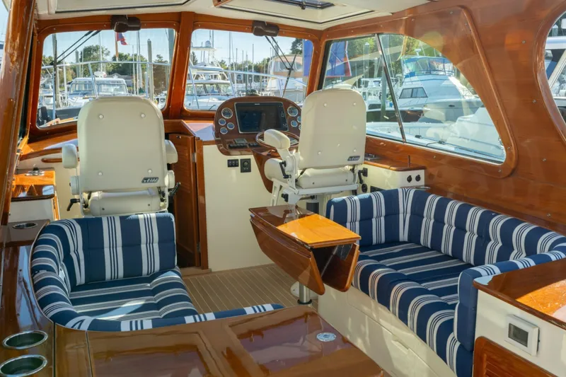 Slide: The Image of Interior of 2015 Hinckley Picnic Boat MK III with striped seating and wooden finishes. - 13