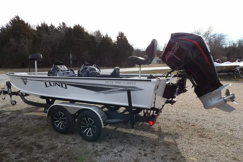 Slide: The Image of 2026 Lund 2075 Pro-V Bass XS boat on trailer, featuring sleek design and powerful outboard motor. - 11