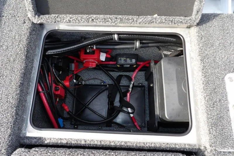 Slide: The Image of 2026 Lund 2075 Pro-V Bass XS boat battery compartment with wiring and components. - 12