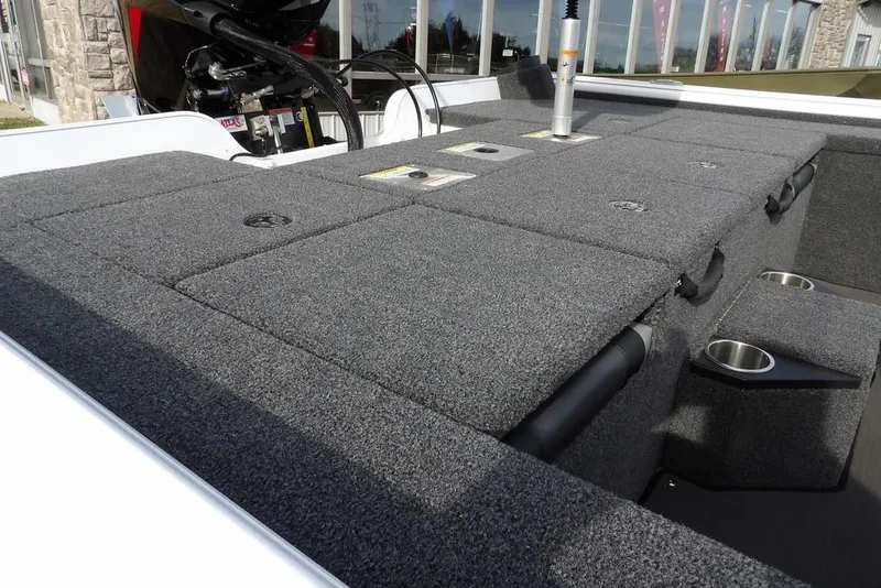 Slide: The Image of 2026 Lund 2075 Pro-V Bass XS boat deck with carpeted storage compartments. - 14