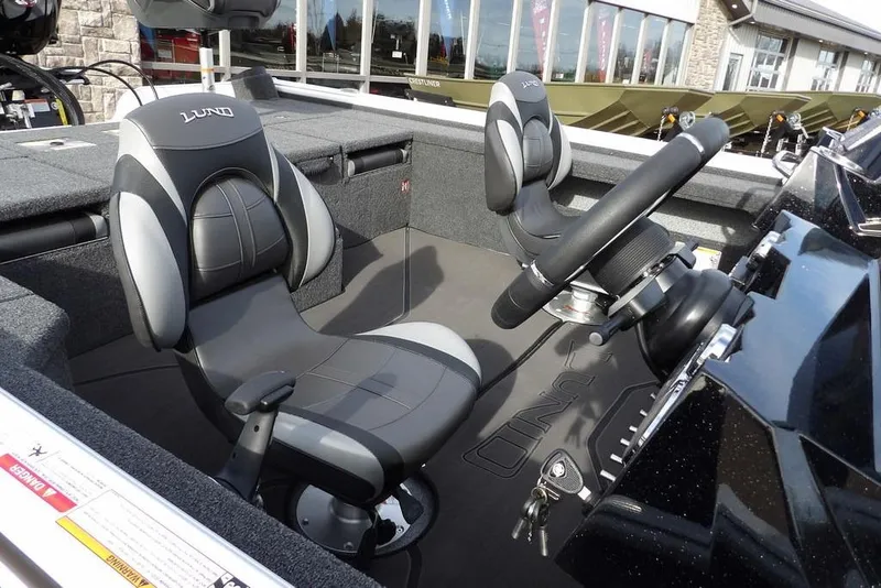 Slide: The Image of 2026 Lund 2075 Pro-V Bass XS boat interior with steering wheel and seats. - 19