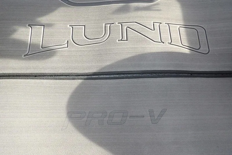 Slide: The Image of 2026 Lund 2075 Pro-V Bass XS boat logo on textured surface. - 30