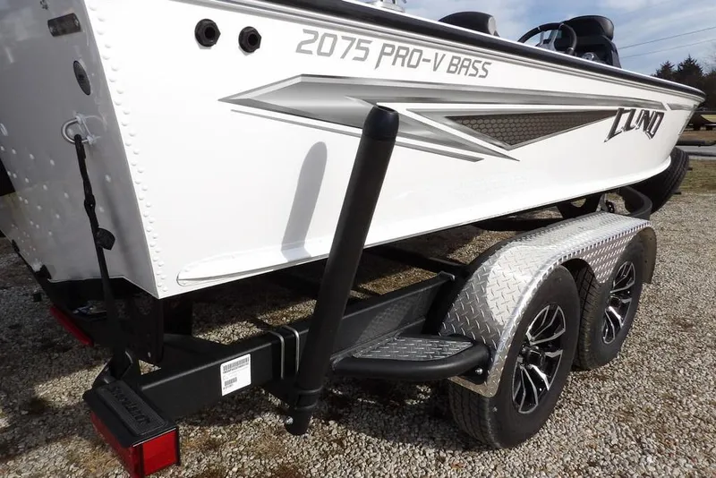 Slide: The Image of 2026 Lund 2075 Pro-V Bass XS boat on a dual-axle trailer, side view. - 56