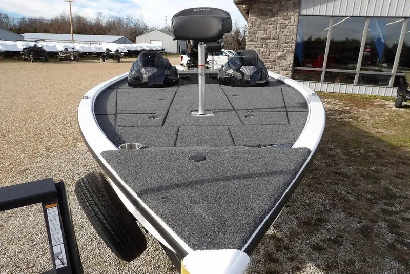 Slide: The Image of 2026 Lund 2075 Pro-V Bass XS boat with spacious deck, parked outdoors. - 57