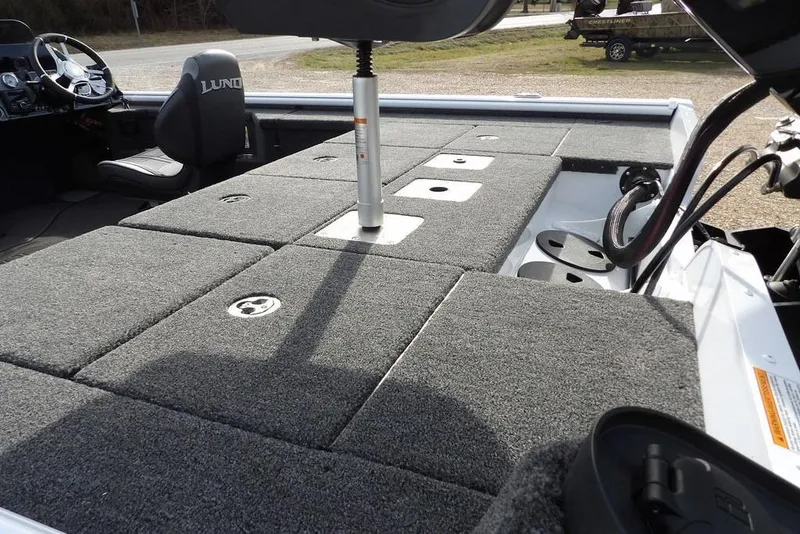 Slide: The Image of 2026 Lund 2075 Pro-V Bass XS boat interior with carpeted deck and seating. - 9