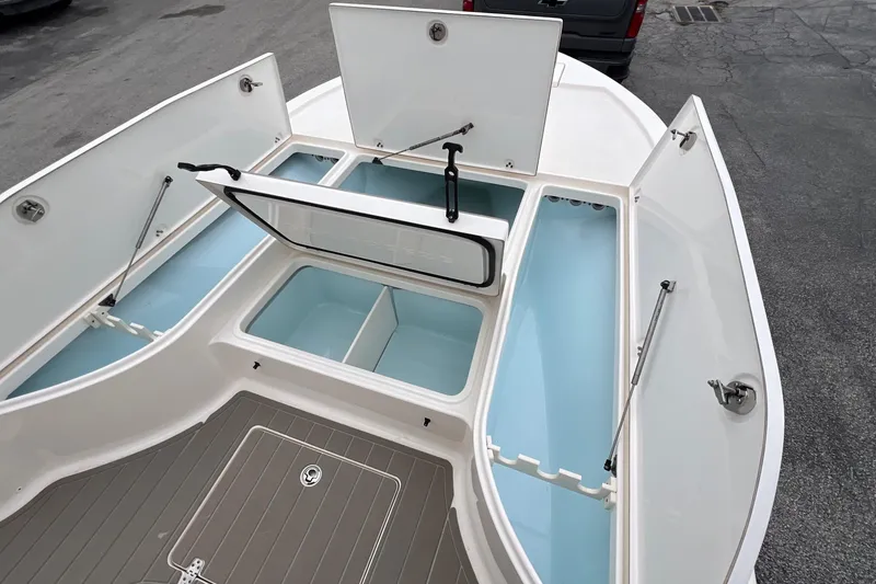 Slide: The Image of 2019 Sea Born FX24 Bay boat with open storage compartments and deck view. - 11