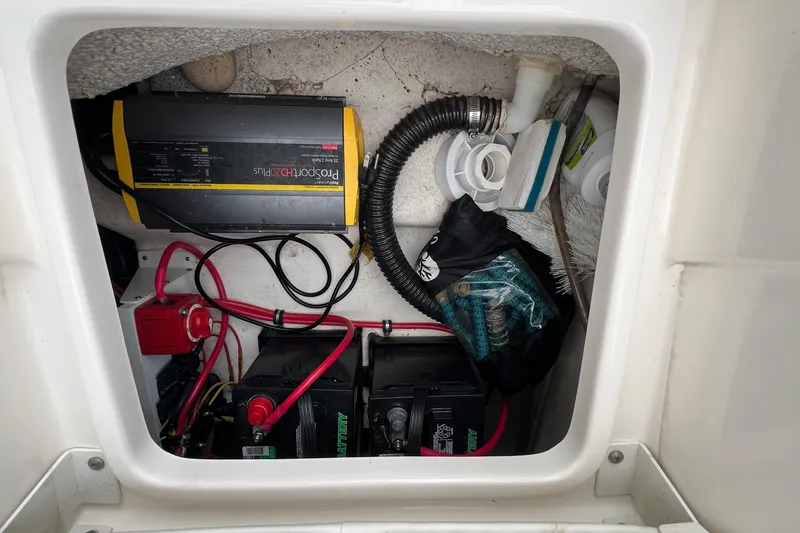 Slide: The Image of 2019 Sea Born FX24 Bay boat battery compartment with charger and wiring. - 24