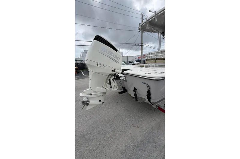 Slide: The Image of 2019 Sea Born FX24 Bay boat with Suzuki outboard motor, parked on pavement. - 4