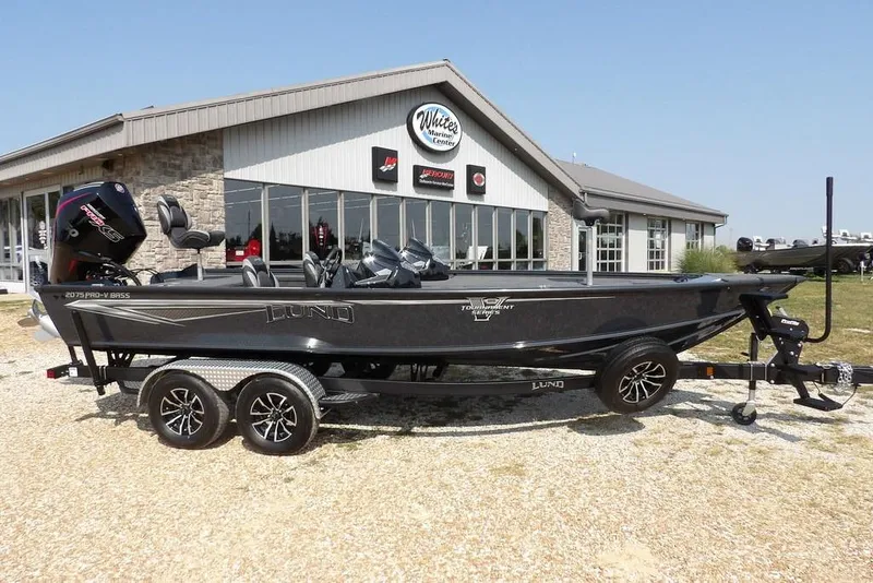 The Image of 2026 Lund 2075 Pro-V Bass XS boat on trailer outside marine center. - 1