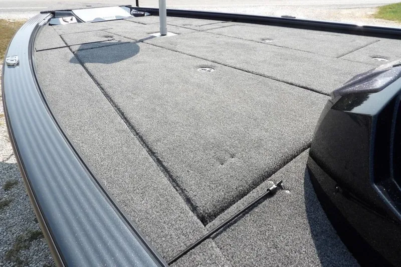 Slide: The Image of 2026 Lund 2075 Pro-V Bass XS boat deck with gray carpet and storage compartments. - 10