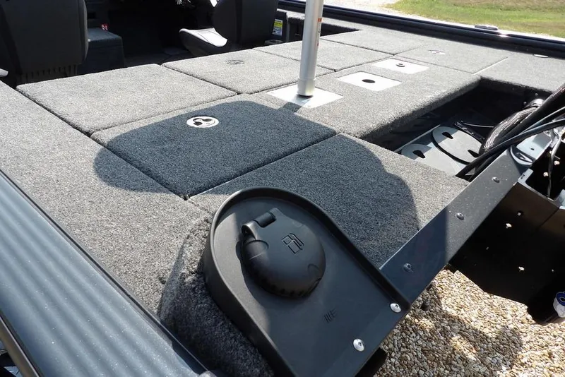 Slide: The Image of 2026 Lund 2075 Pro-V Bass XS boat deck with storage compartments and fuel cap. - 13