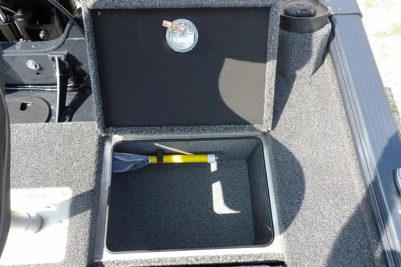 Slide: The Image of Storage compartment in 2026 Lund 2075 Pro-V Bass XS boat, featuring a yellow handle tool. - 15