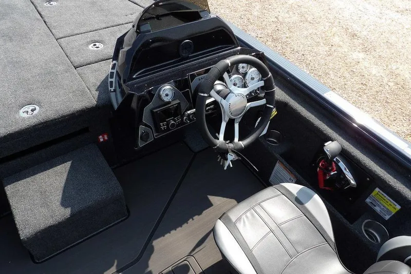 Slide: The Image of 2026 Lund 2075 Pro-V Bass XS boat cockpit with steering wheel and control panel. - 27