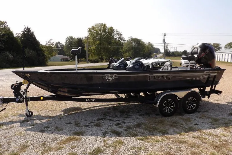 Slide: The Image of 2026 Lund 2075 Pro-V Bass XS boat on trailer, parked outdoors. - 3