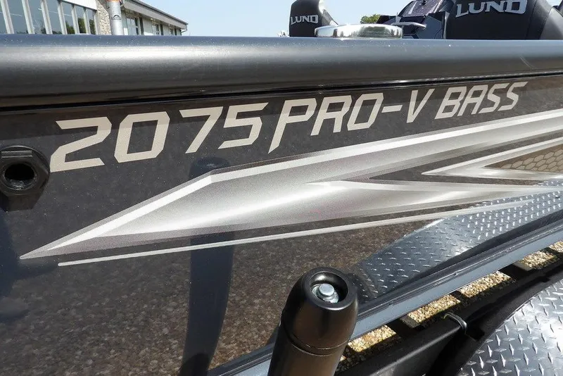 Slide: The Image of 2026 Lund 2075 Pro-V Bass XS boat, close-up of model name on hull. - 55