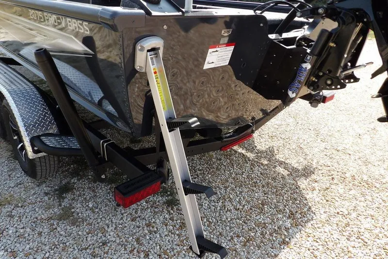 Slide: The Image of 2026 Lund 2075 Pro-V Bass XS boat with ladder on gravel surface. - 61