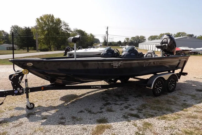 Slide: The Image of 2026 Lund 2075 Pro-V Bass XS boat on trailer, parked outdoors. - 8