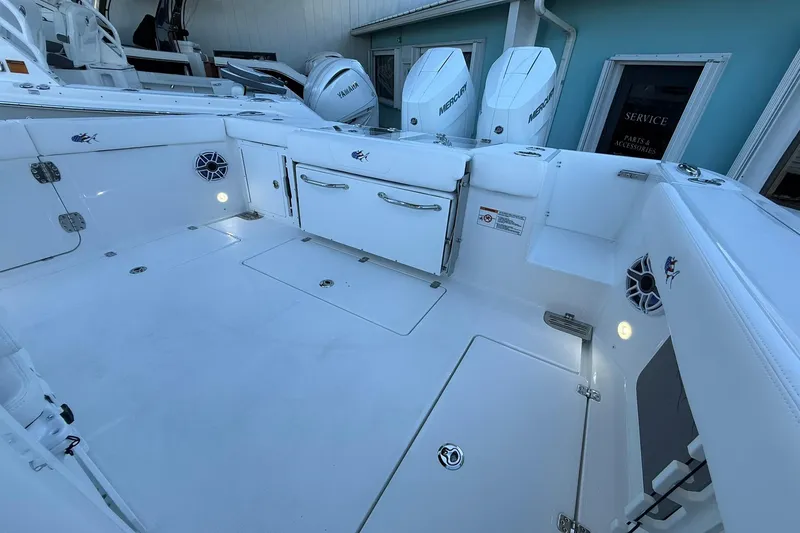 Slide: The Image of 2026 Crevalle 33 CSF boat deck with storage, speakers, and dual outboard engines. - 11