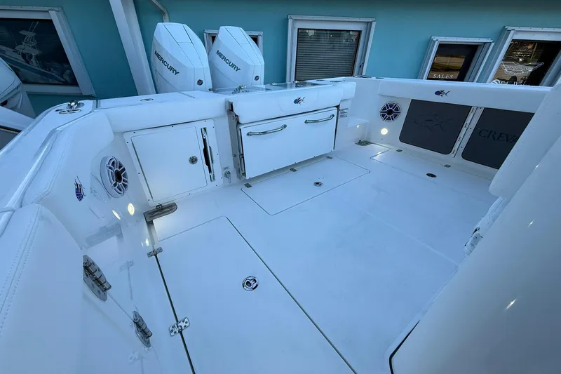 Slide: The Image of 2026 Crevalle 33 CSF boat deck with storage, speakers, and Mercury engines. - 12