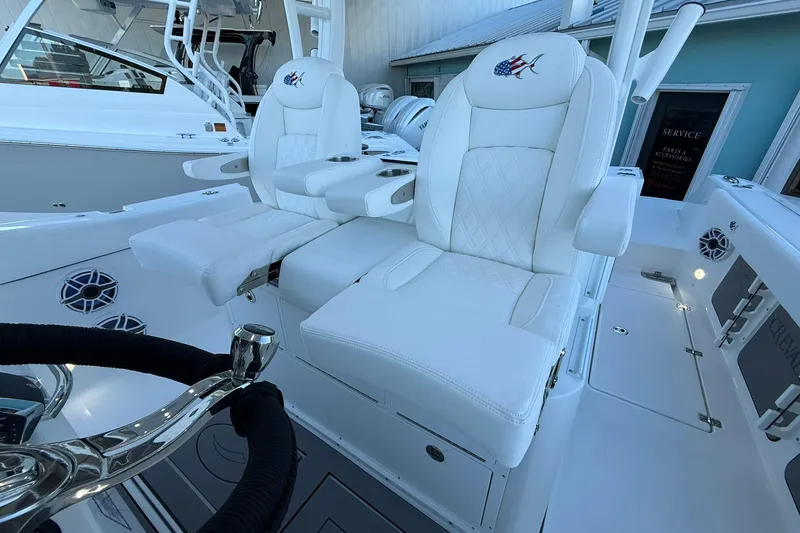 Slide: The Image of Luxurious white seating on 2026 Crevalle 33 CSF boat, featuring cup holders and embroidered logo. - 30