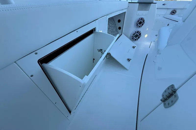 Slide: The Image of 2026 Crevalle 33 CSF boat interior with open storage compartment and speakers. - 36