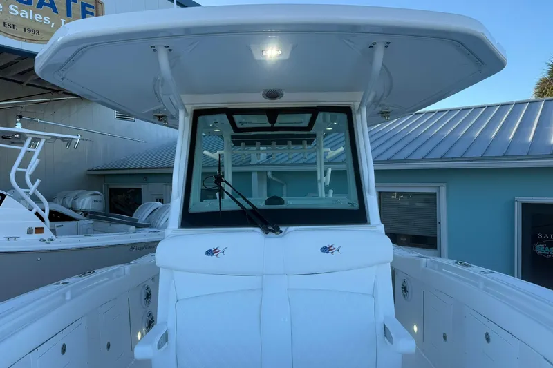 Slide: The Image of 2026 Crevalle 33 CSF boat with T-top and windshield, docked at a marina. - 64