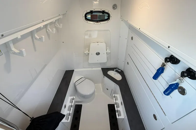 Slide: The Image of 2026 Crevalle 33 CSF boat interior with toilet, sink, and storage hooks. - 67
