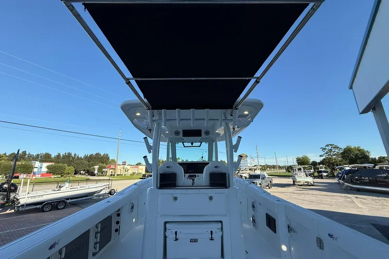 Slide: The Image of 2026 Crevalle 33 CSF boat with T-top, docked under clear blue sky. - 8