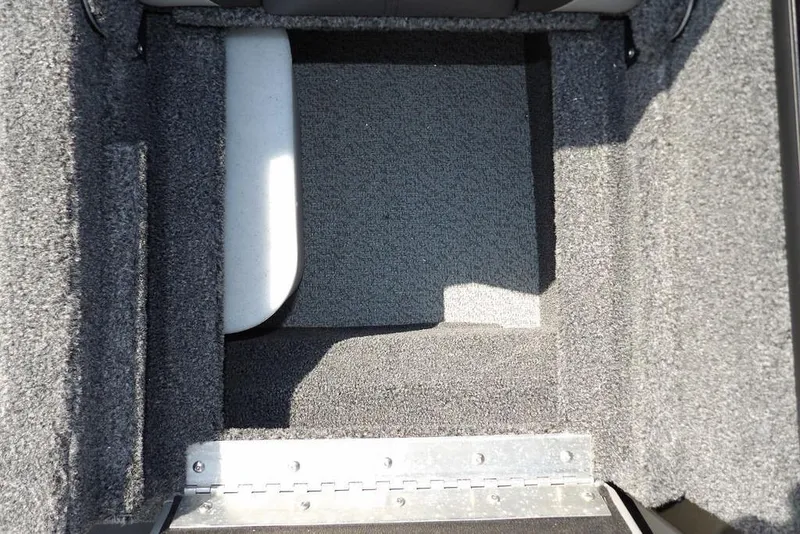 Slide: The Image of Interior storage compartment of 2026 Lund 2075 Pro-V Sport boat, featuring carpeted finish. - 13