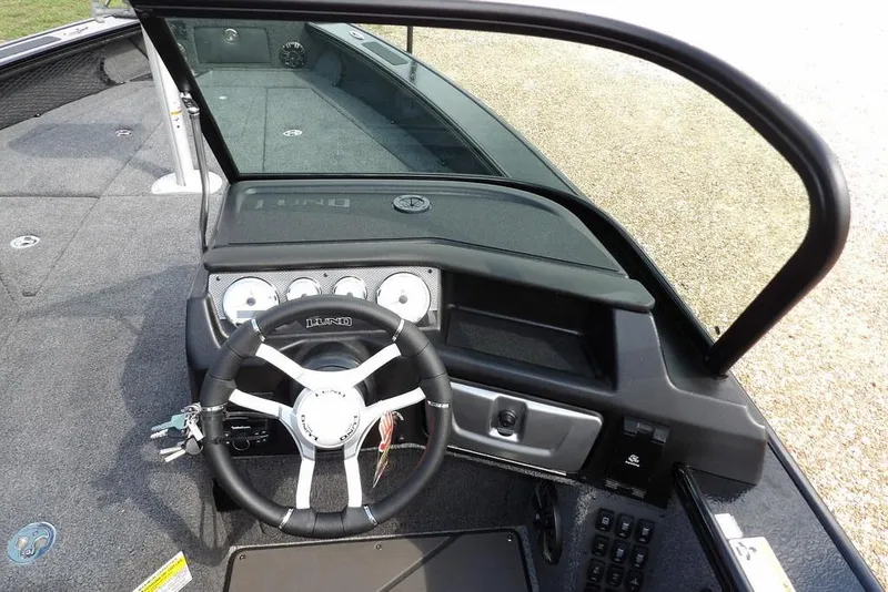 Slide: The Image of 2026 Lund 2075 Pro-V Sport boat dashboard with steering wheel and gauges. - 24