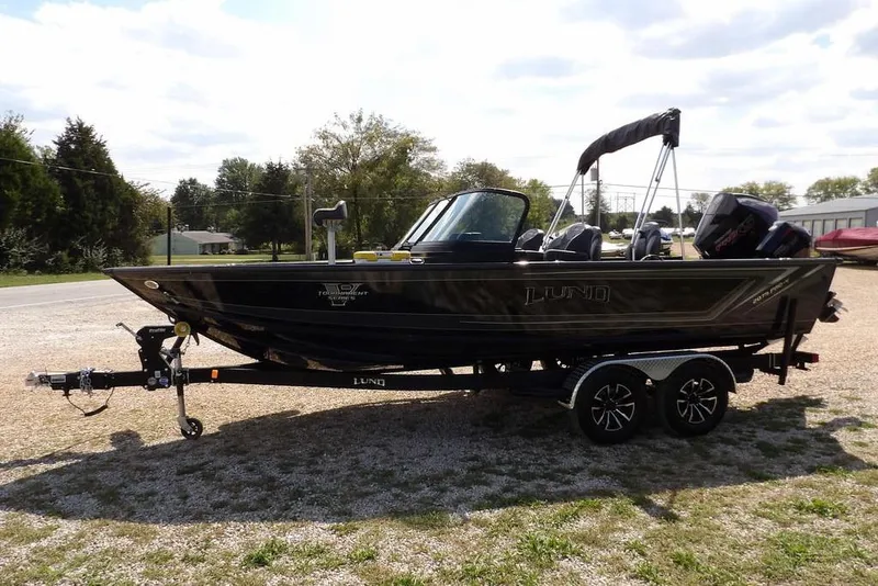 Slide: The Image of 2026 Lund 2075 Pro-V Sport boat on trailer, parked outdoors on gravel. - 4