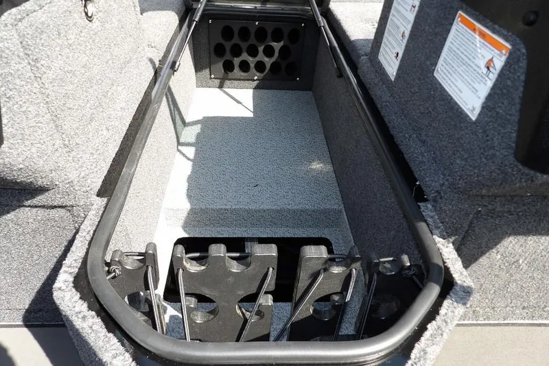 Slide: The Image of 2026 Lund 2075 Pro-V Sport boat storage compartment with rod holders and carpeted interior. - 44