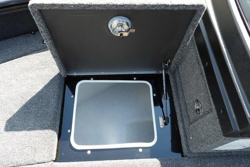 Slide: The Image of Open storage compartment in 2026 Lund 2075 Pro-V Sport boat, featuring carpeted interior. - 46
