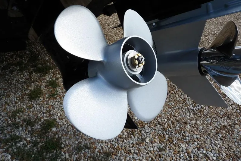 Slide: The Image of Close-up of a 2026 Lund 2075 Pro-V Sport boat propeller on gravel surface. - 68