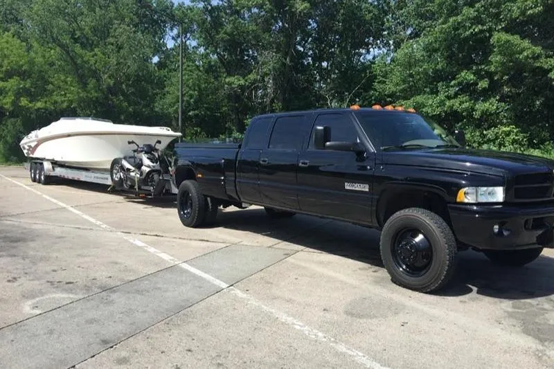 Slide: The Image of Black truck towing 1997 Fountain 42 Lightning boat and motorcycle in parking lot. - 7