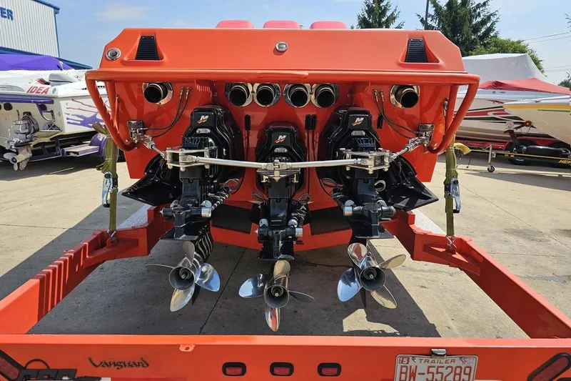 Slide: The Image of 1995 Hustler 40 Fiore boat with triple outboard engines on a trailer. - 12