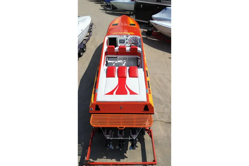 Slide: The Image of 1995 Hustler 40 Fiore speedboat with vibrant orange and red seating, docked on a trailer. - 17