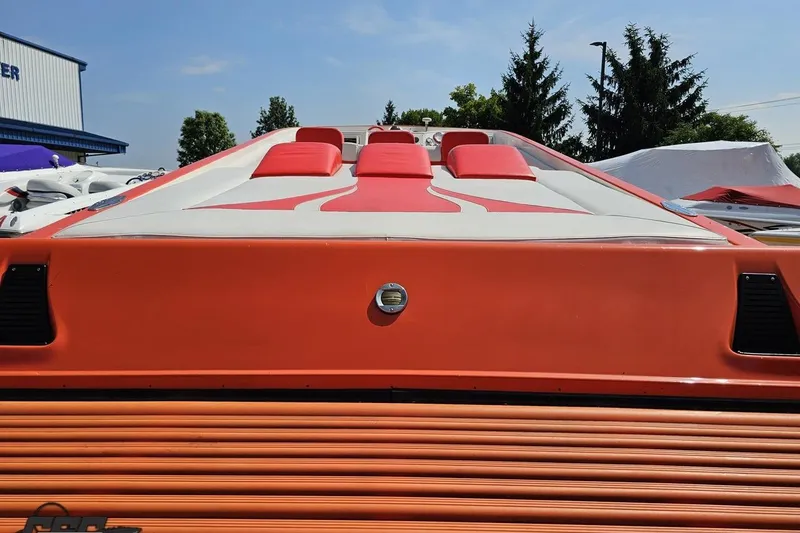 Slide: The Image of 1995 Hustler 40 Fiore speedboat with vibrant orange and white design, docked outdoors. - 19