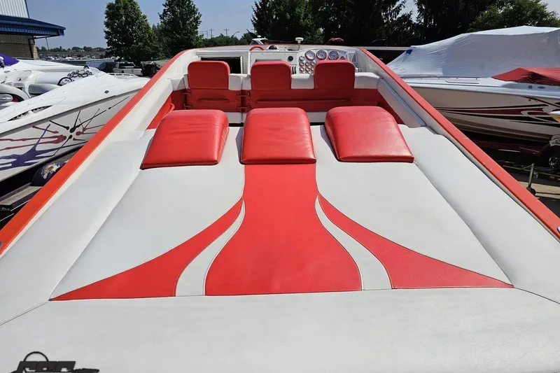 Slide: The Image of 1995 Hustler 40 Fiore boat with red and white seating, docked outdoors. - 20