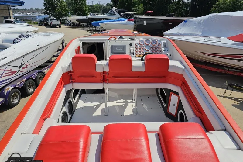 Slide: The Image of 1995 Hustler 40 Fiore boat interior with red seating and control panel. - 22
