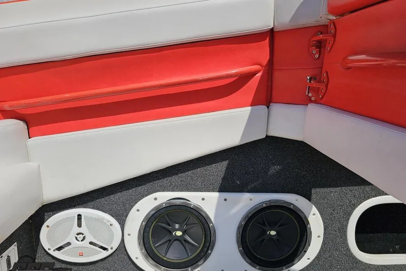 Slide: The Image of Interior of 1995 Hustler 40 Fiore boat with red and white seating, speakers visible. - 23