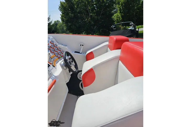 Slide: The Image of 1995 Hustler 40 Fiore boat interior with red and white seating and control panel. - 25