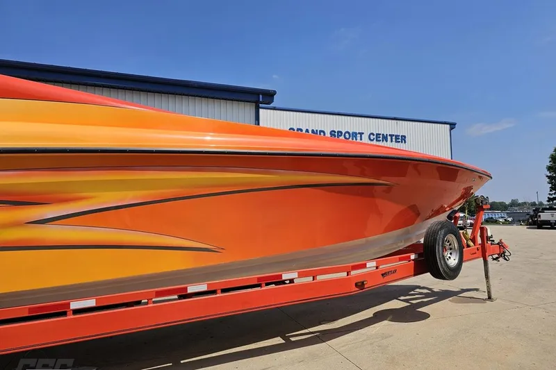 Slide: The Image of Orange 1995 Hustler 40 Fiore boat on trailer at Grand Sport Center. - 3