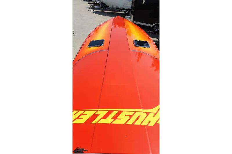Slide: The Image of 1995 Hustler 40 Fiore boat with vibrant orange and yellow design, viewed from above. - 32