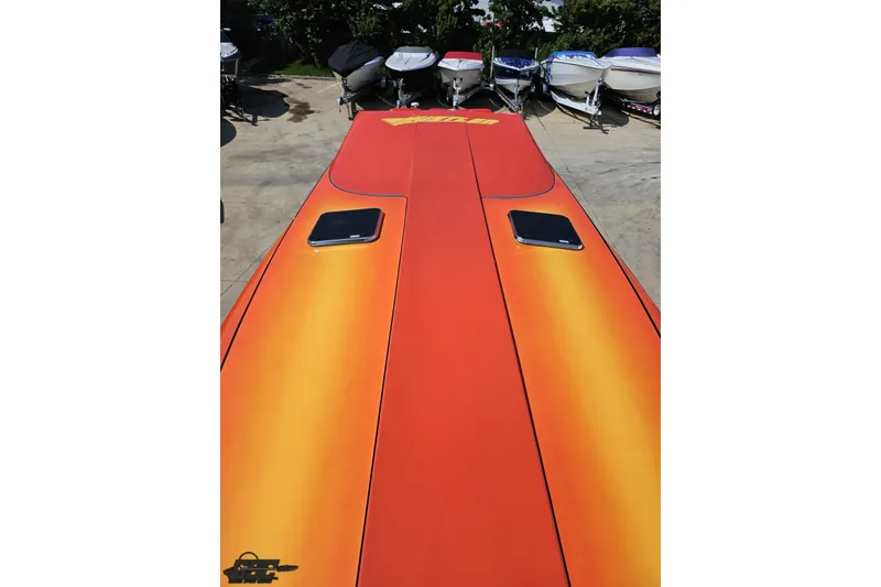 Slide: The Image of 1995 Hustler 40 Fiore boat with vibrant orange and yellow deck, surrounded by other boats. - 37