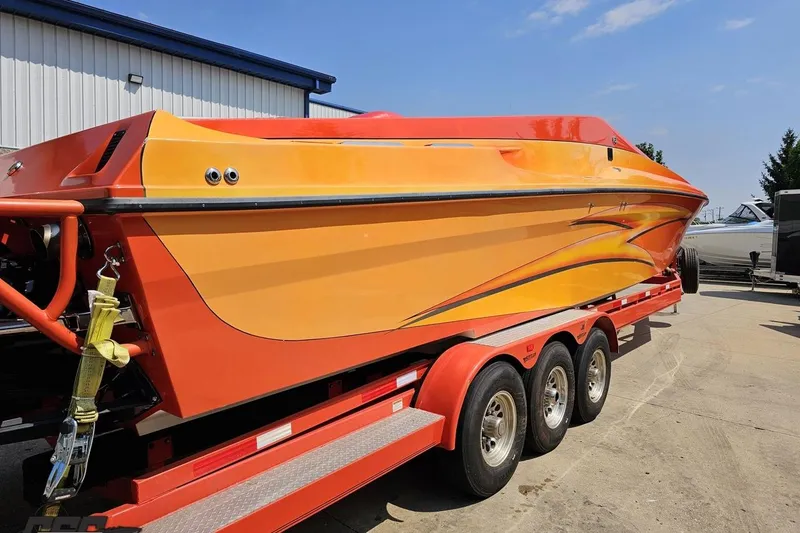 Slide: The Image of 1995 Hustler 40 Fiore speedboat in vibrant orange and yellow on a trailer. - 5