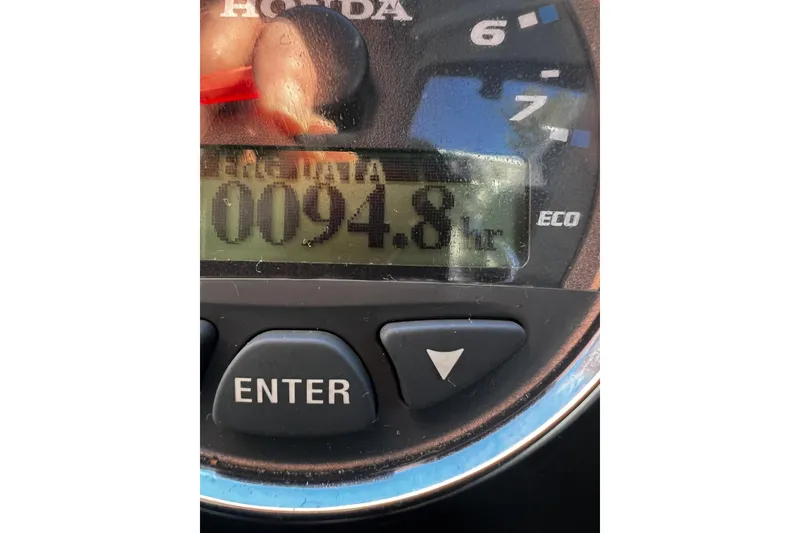 Slide: The Image of Close-up of a Honda boat gauge displaying 94.8 hours on a 2018 Hewescraft 220 Ocean Pro ET HT. - 15