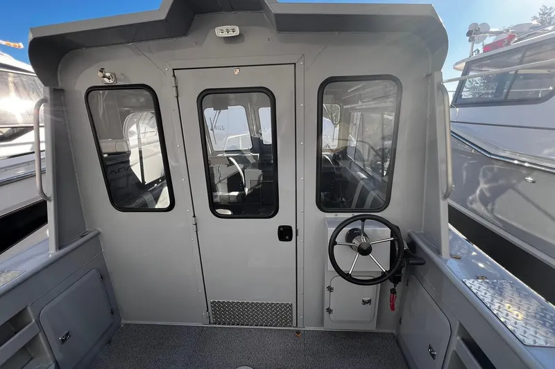 Slide: The Image of 2018 Hewescraft 220 Ocean Pro ET HT boat interior with steering wheel and windows. - 6