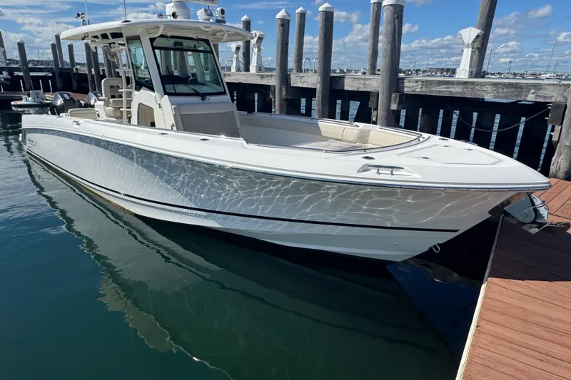 The Image of 2019 Boston Whaler 330 Outrage boat docked at marina under clear blue sky. - 0